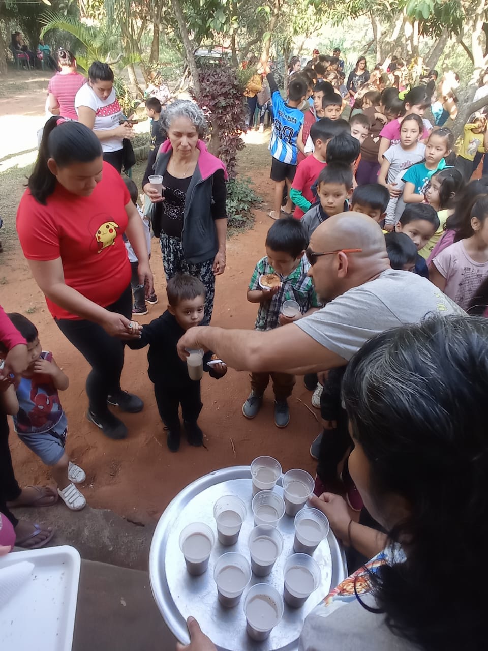 Voluntarios de la ONG sirviendo merienda a niños
